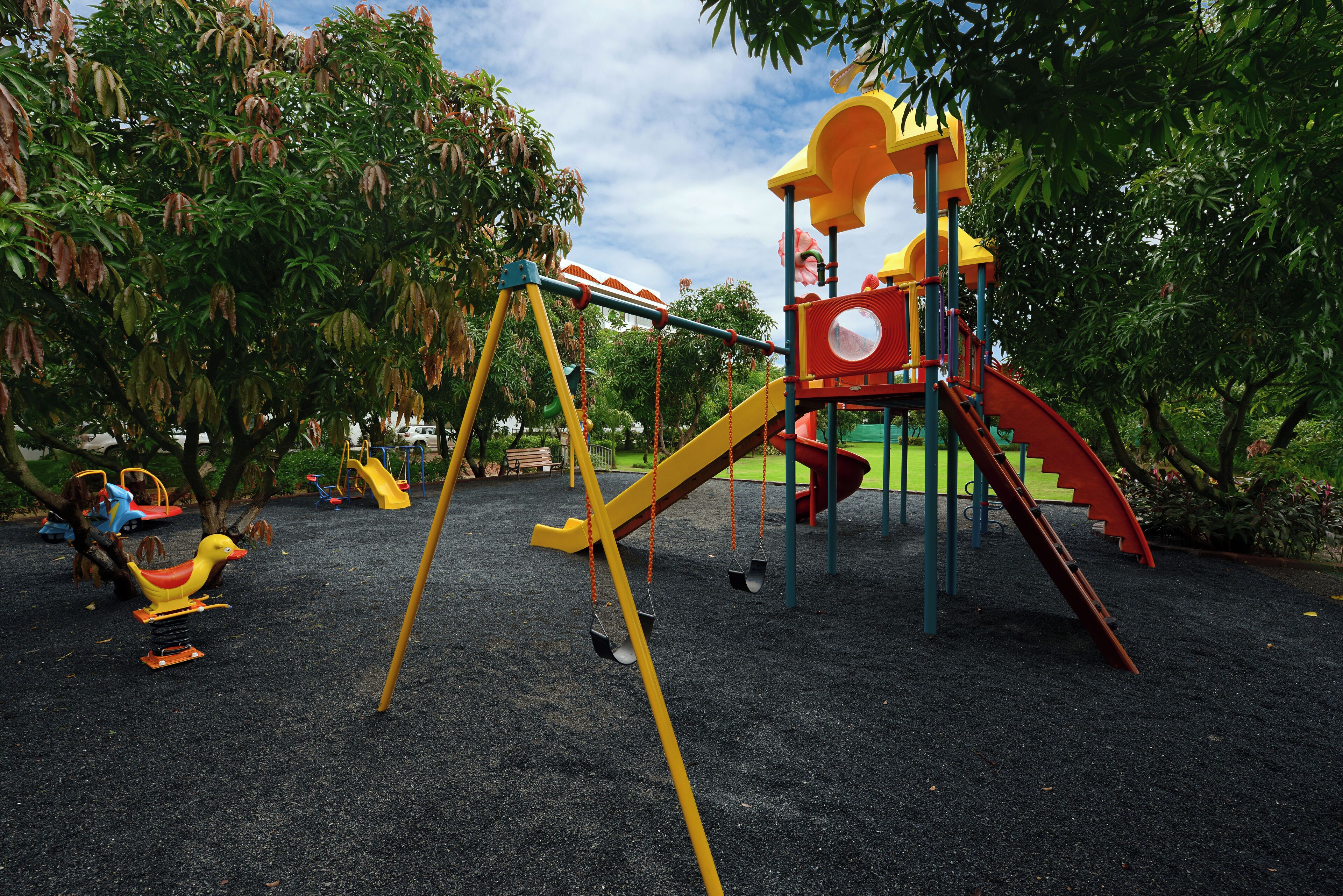 Un parque infantil con columpios, toboganes y una estructura para escalar.