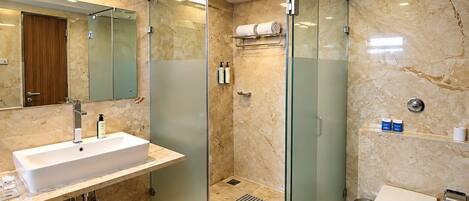 A modern bathroom with a glass-enclosed shower, a sink with a mirror, and a toilet.