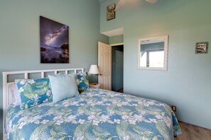 Ein Schlafzimmer mit Bett, Wandgemälde mit Sternenhimmel, einer Tür und einem Spiegel.