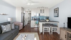 A modern kitchen with white cabinets, a central island, and a dining area with stools. - 3rd Floor Condo w/Amazing Ocean View! Pool & Pier Access! *Unit 328* (Isle Of Palms)