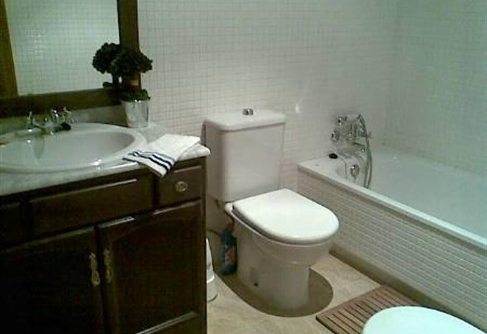 Une salle de bain avec un lavabo, des toilettes et une baignoire.