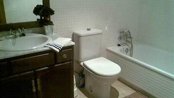 Une salle de bain avec un lavabo, des toilettes et une baignoire.