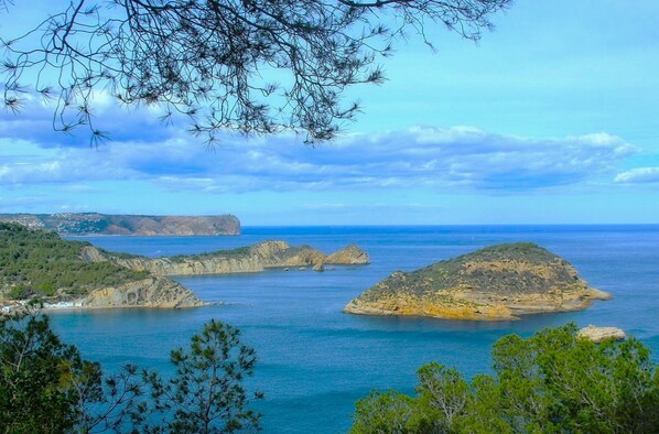 Eine Küstenlandschaft mit Felsformationen und blauem Meer.