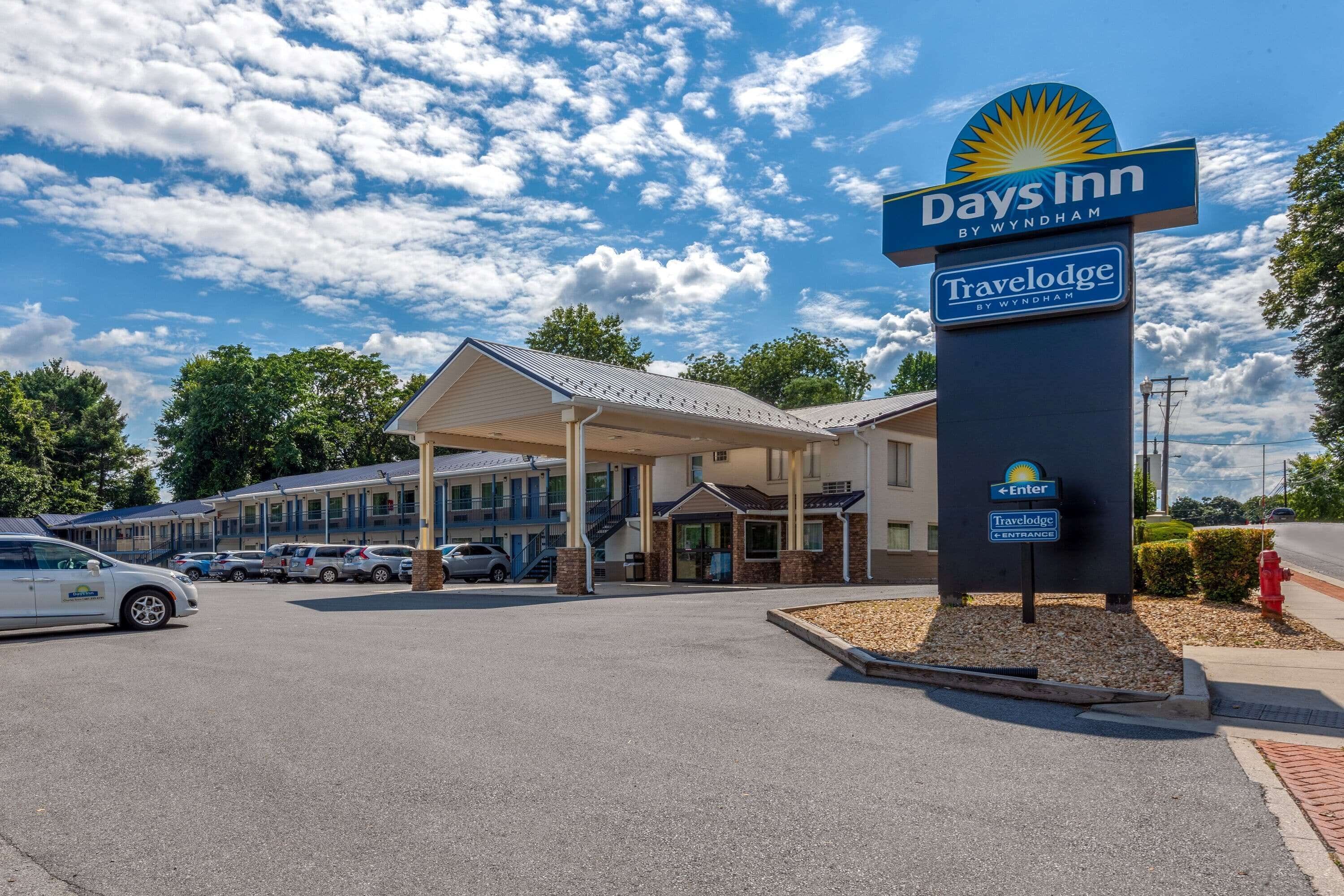 Un Days Inn Travelodge by Wyndham con ingresso coperto, diversi posti auto e cielo sereno.