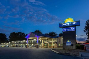 Edificio de Days Inn by Wyndham Travelodge con entrada iluminada y estacionamiento.