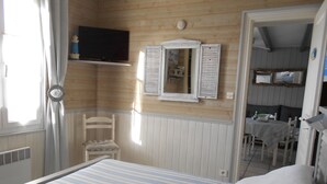 Une chambre à coucher avec un lit, une chaise, une table et un téléviseur.