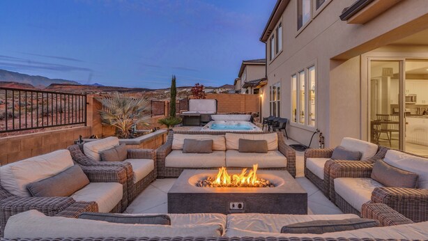 Une terrasse dotée de meubles en osier, d’un foyer extérieur et d’un bain à remous.