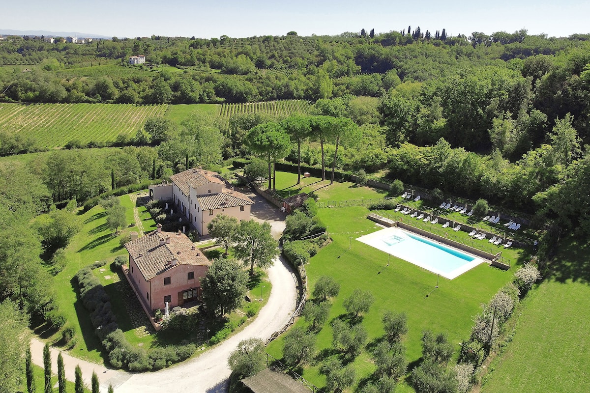 A large estate with a swimming pool, tennis court, and vineyard.