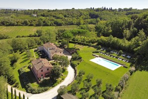 Una extensa propiedad con piscina, cancha de tenis y viñedo.