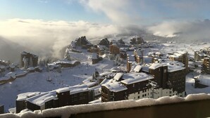 Un pueblo cubierto de nieve con edificios y una pista de esquí.