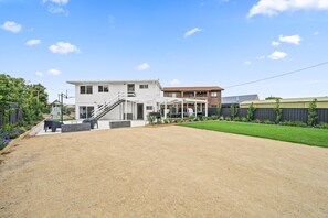 A modern two-story house with a covered patio, a gravel driveway, and a well-maintained lawn. - The HardyOne ~ Aldinga Beach - Stunning Abode in Serene Silver Sands (Aldinga Beach)
