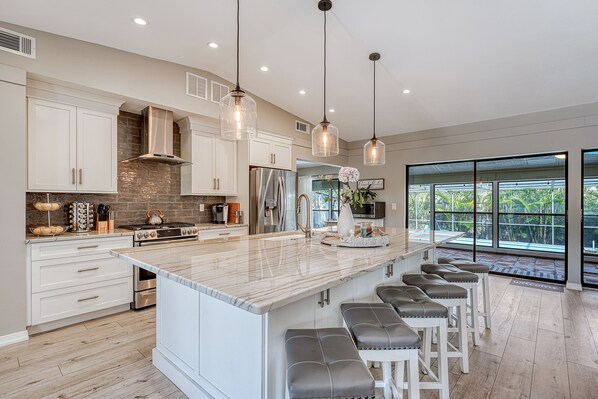 Kitchen alternate angle highlighting the large island with bar seating and pendant lighting