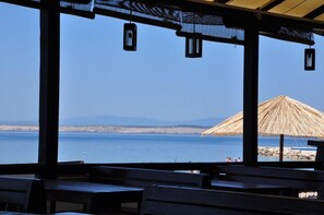 Relax in a shaded seating area overlooking the ocean and distant mountains.