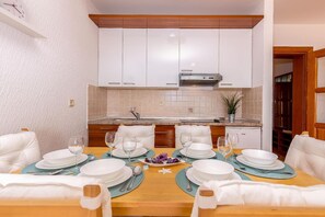 Enjoy meals in this cozy dining area with a table for four and modern kitchen.