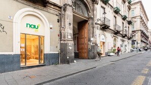 A street view with a storefront labeled 'nau' featuring a glass entrance. - GuestHost - Cozy 70 sqm apartment, perfect for two people, located on the third floor of a period building in good condition with a lift (NOT suitable for disabled people). The property is located along via Etnea, the main shopping street in Catania, and (Catania)