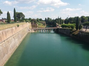 Ein Fluss mit einer Brücke, umgeben von Grünflächen und Gebäuden.