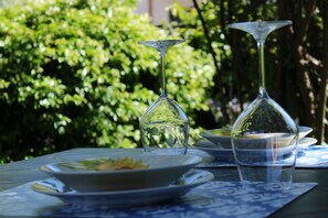 Ein Tisch, gedeckt mit einem Teller, einem Glas und einer Schüssel.