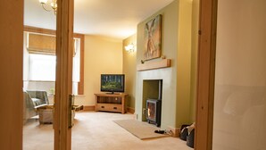 A living room with a fireplace, a television, and a painting on the wall. - Lime Kiln Farm, Malton, North York Moors (Malton)