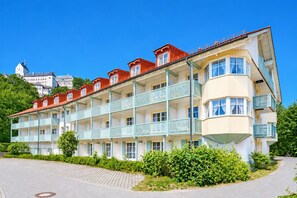 A multi-story hotel with balconies, a paved driveway, and a clear sky. - Kampenwand Apartment (Aschau im Chiemgau)