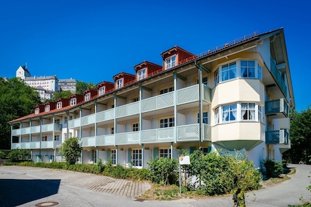 Un hotel a più piani con balconi, un'unità d'angolo e un'area di parcheggio.. Apartment Kampenwand