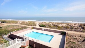 Ein rechteckiger Pool mit Blick auf Strand und Meer.