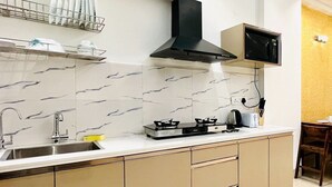 Una cocina moderna con estufa a gas, microondas y extractor de humos negro.