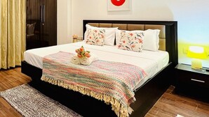 Un dormitorio moderno con una cama grande, un ventilador de techo y un aplique de pared.