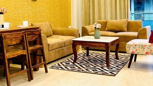 Una sala de estar con dos sofás, una mesa de centro y un comedor con sillas.