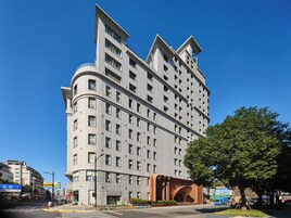 A modern multi-story hotel with a curved facade, large windows, and a distinctive architectural design.