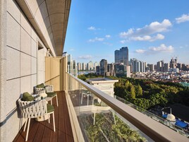 Un balcone con vista sulla città, un pontile in legno e una ringhiera in vetro.