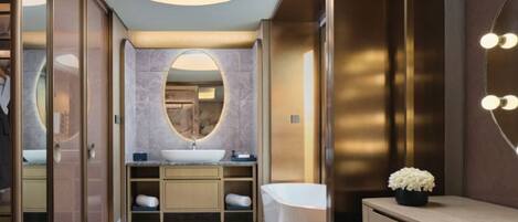 A modern bathroom with a vanity, sink, mirror, and a freestanding bathtub.
