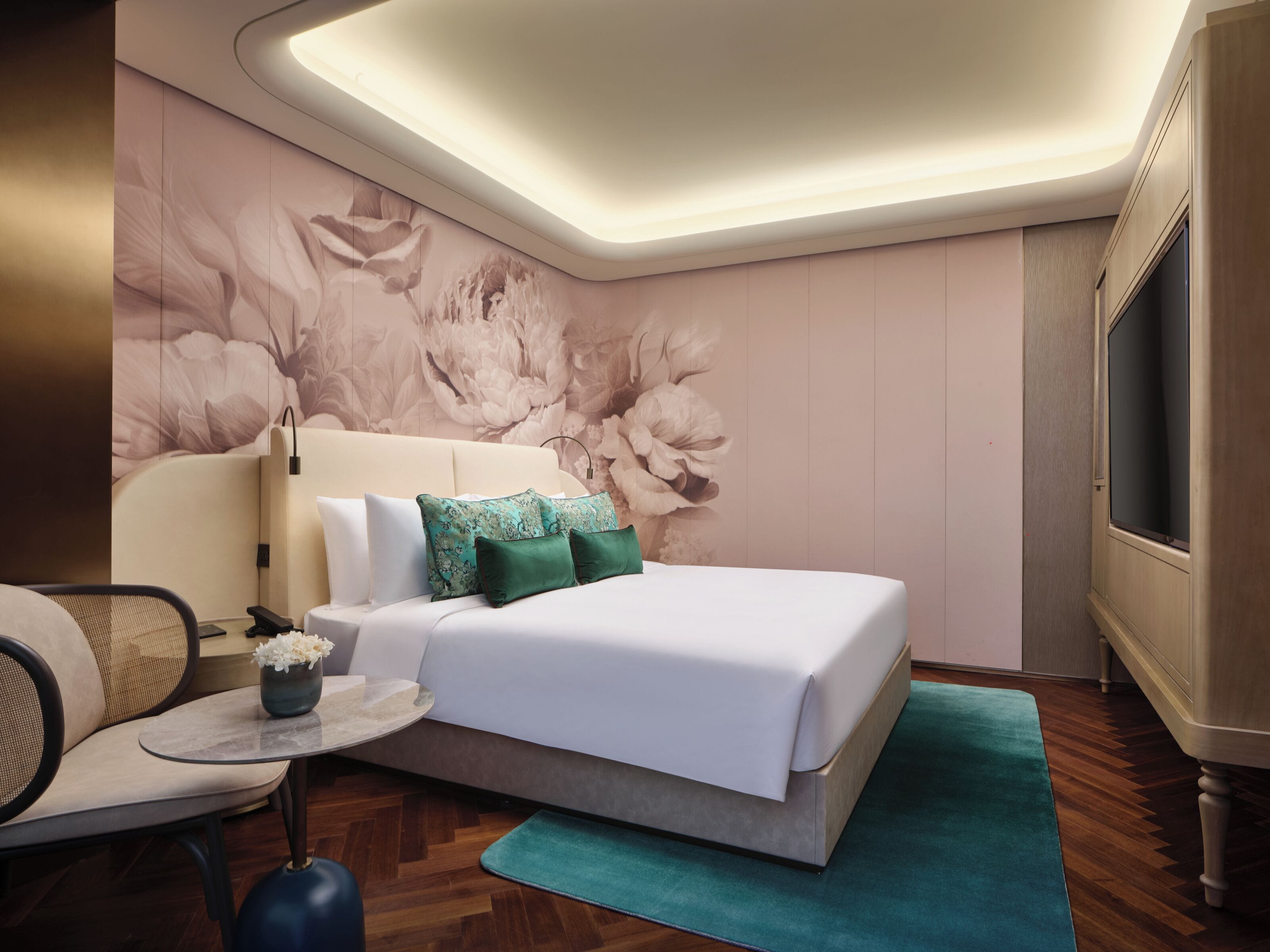 Un dormitorio moderno con una cama grande, una mesita de noche, una silla y un televisor.