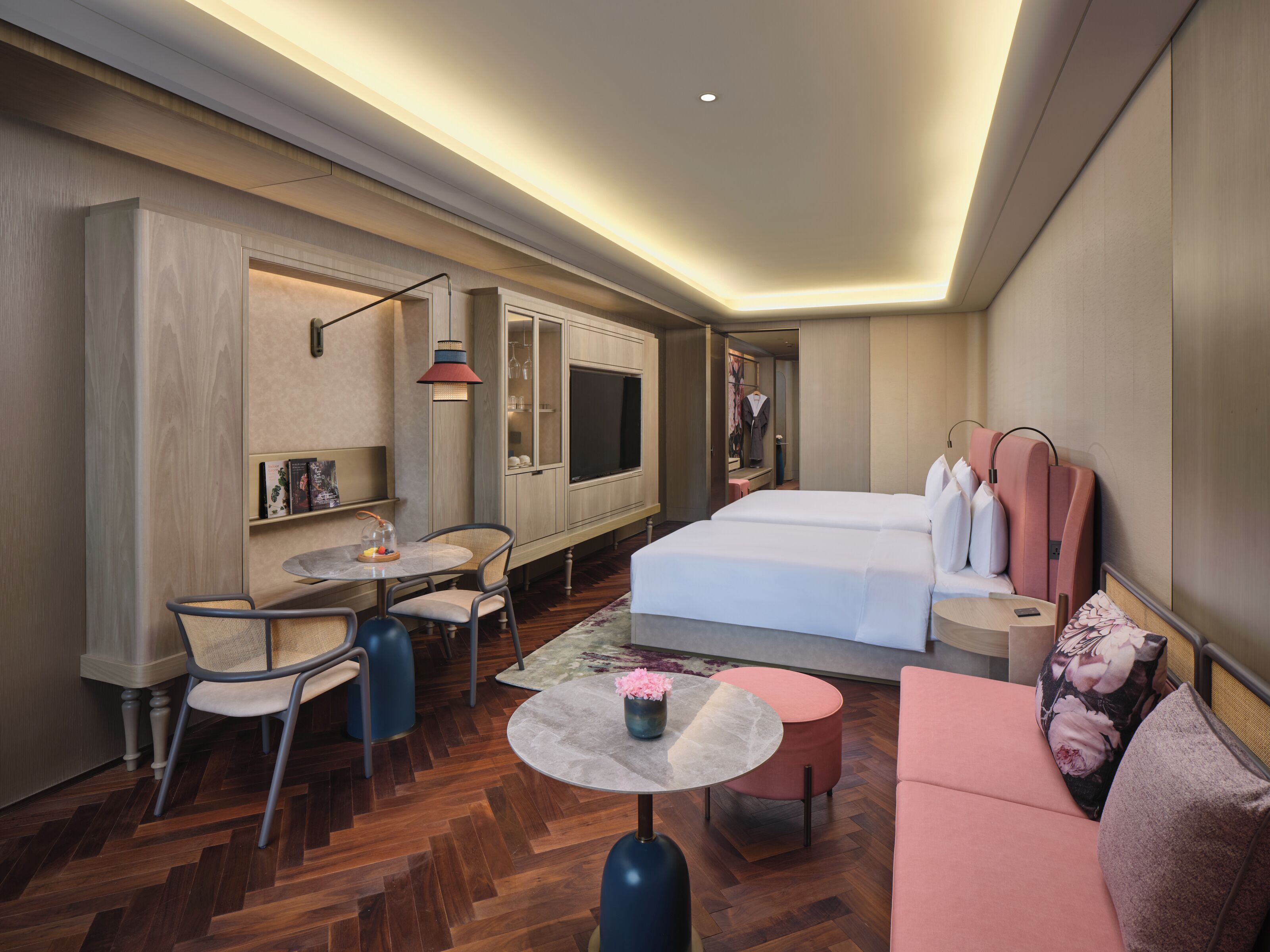Een hotelkamer met een bed, een bureau, een stoel, een bijzettafeltje en een bank.