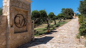 A stone pathway leading to a building with a carved 'G' on the wall.