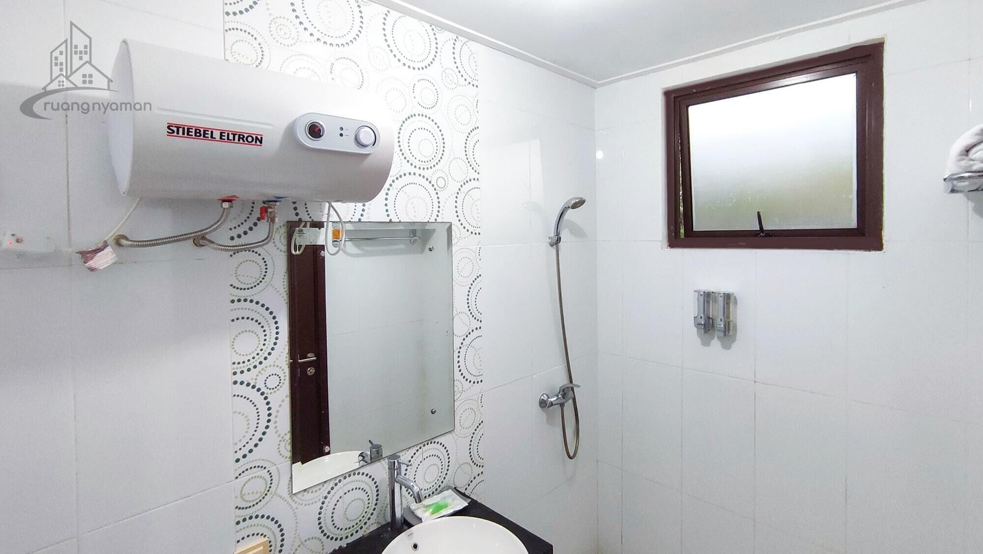 A bathroom with a shower, a toilet, a sink, a mirror, and a towel rack.