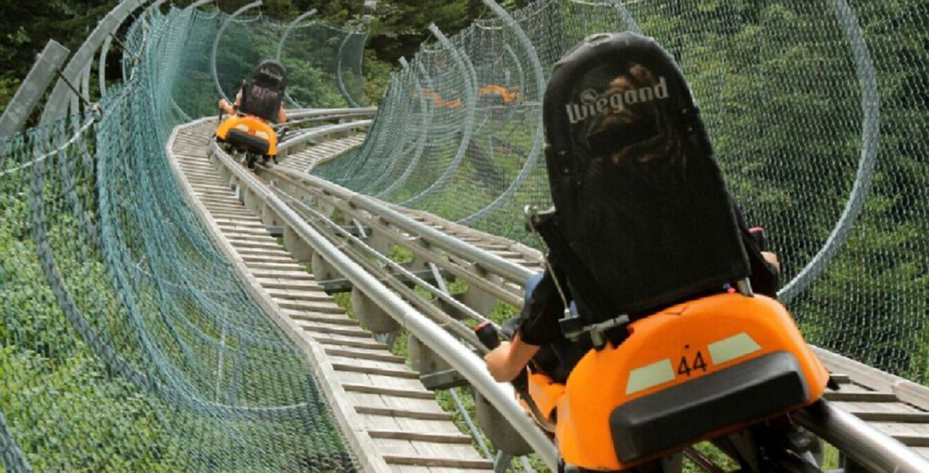 Des montagnes russes avec des rails en bois et un filet de sécurité.