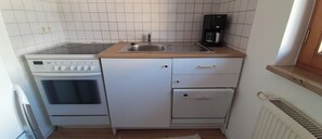 Compact kitchen with a gas stove, sink, and coffee maker, plus a dishwasher and ample cabinetry.