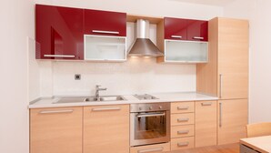 Una cocina moderna con armarios de madera, horno de acero inoxidable y un lavamanos doble.