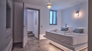 A modern bedroom with a built-in bed, a walk-in closet, and a large window providing natural light. - OLEA VILLA (NAOUSA)