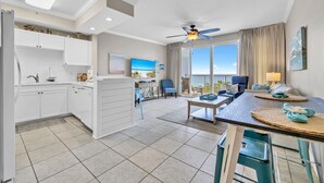 A modern hotel room with a balcony, a kitchen area, and a living space with a sofa and coffee table. - Gulf 513-2 BED/2 BATH-sleeps 6-VIEWS OF POOL AND BEACH!  Updated (Fort Walton Beach)