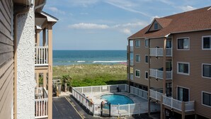Un immeuble doté d’une piscine, offrant une vue sur la plage et comprenant des balcons.