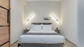 Une chambre moderne avec un grand lit, deux tables de chevet avec des lampes et un panneau indiquant « détente » sur le mur.
