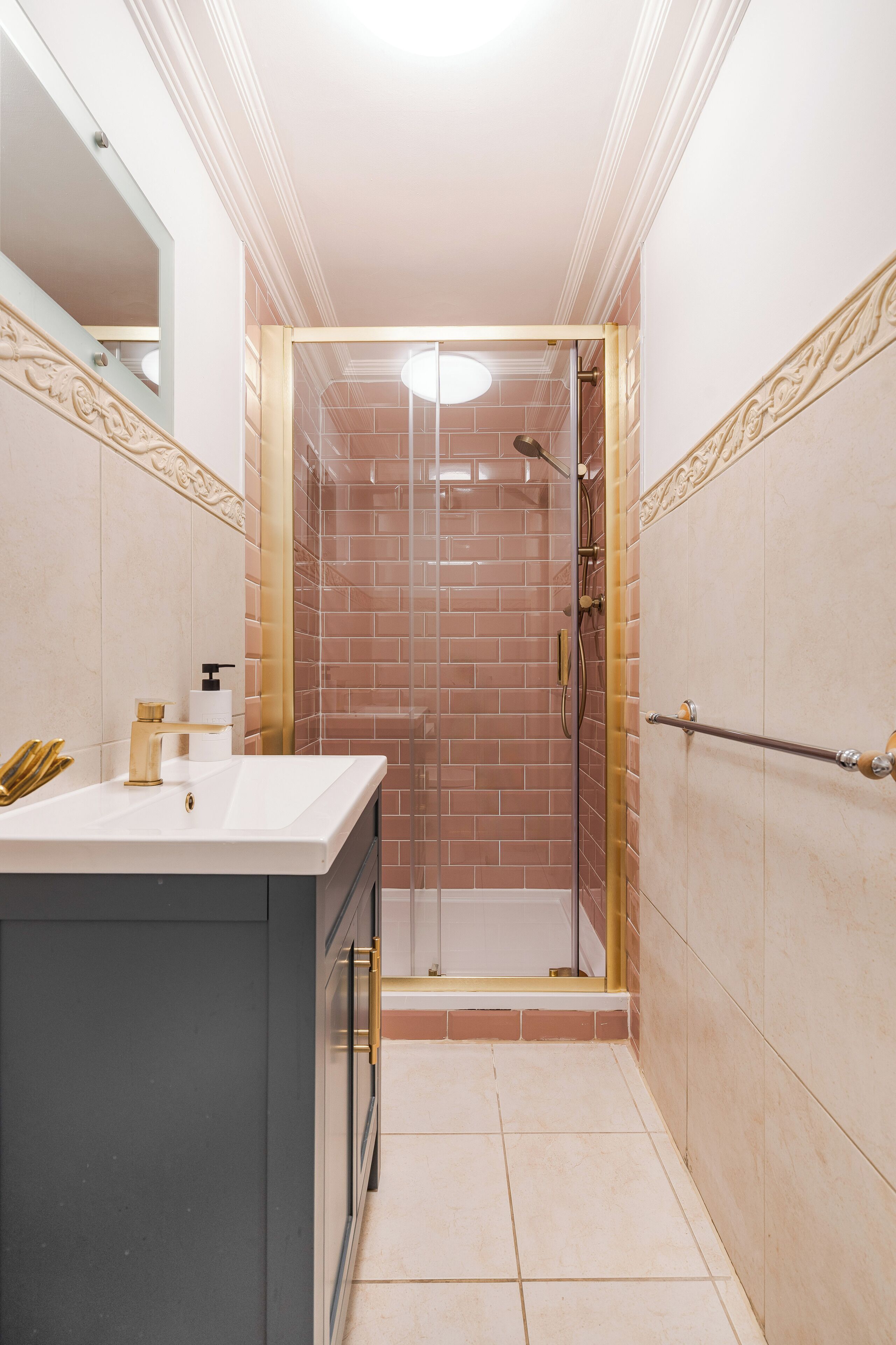 Un baño con ducha, lavamanos y espejo.