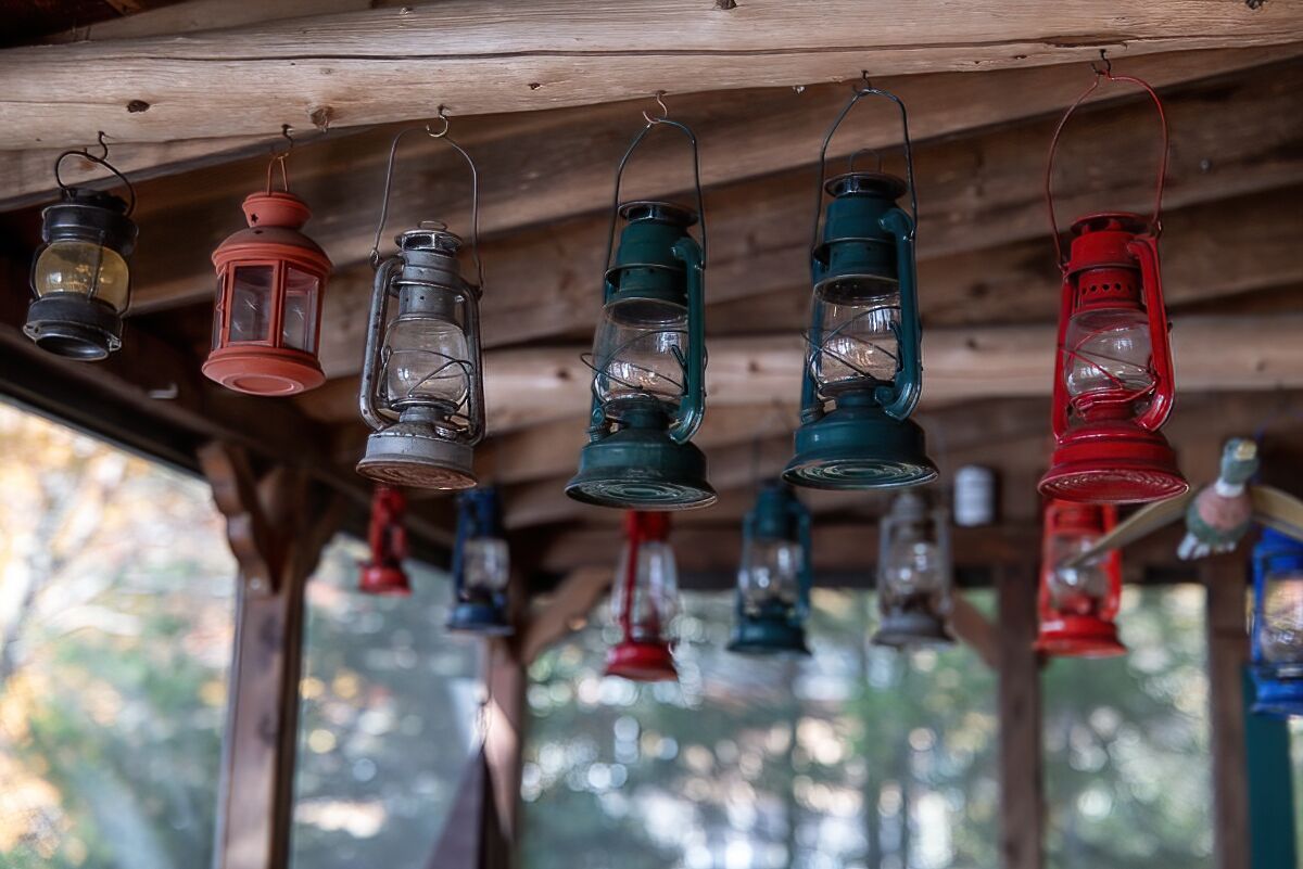 Une structure en bois ornée de nombreuses lanternes suspendues de différentes couleurs.