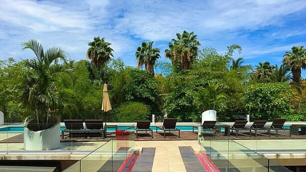 A rooftop pool area with lounge chairs and a glass balustrade. - Stylish Duplex Retreat 2BR Pool Nuevo Vallarta (Nuevo Vallarta)