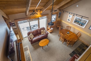 Relax in this inviting living area with a high ceiling, leather sofa, and dining table.