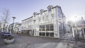 A multi-story building with large windows and a ground-level entrance. - Backyard Stylish Studio for 2 - Excellent Location (Reykjavík)
