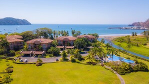 Un complexe hôtelier comprenant plusieurs bâtiments, une piscine et offrant une vue sur la plage.