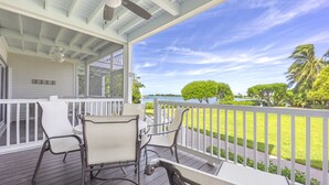 A covered outdoor area with a table and chairs, a ceiling fan, and a view of a lake and trees. - Waterfront Duck Key Villa - Sleeps 6 (Duck Key)