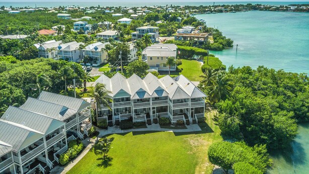 A coastal resort with multiple-story buildings, a marina, and lush greenery. - Waterfront Duck Key Villa - Sleeps 6 (Duck Key)